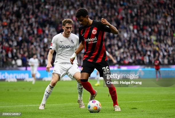 Ansgar Knauff of Eintracht Frankfurt runs with the ball under pressure from Patrick Osterhage of VfL Bochum during the Bundesliga match between...