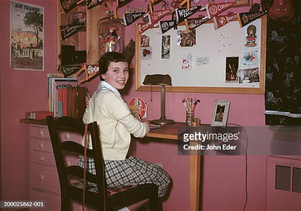 teenage girl (13-15), sitting at desk in room, portrait - 1950s bedroom stock pictures, royalty-free photos & images