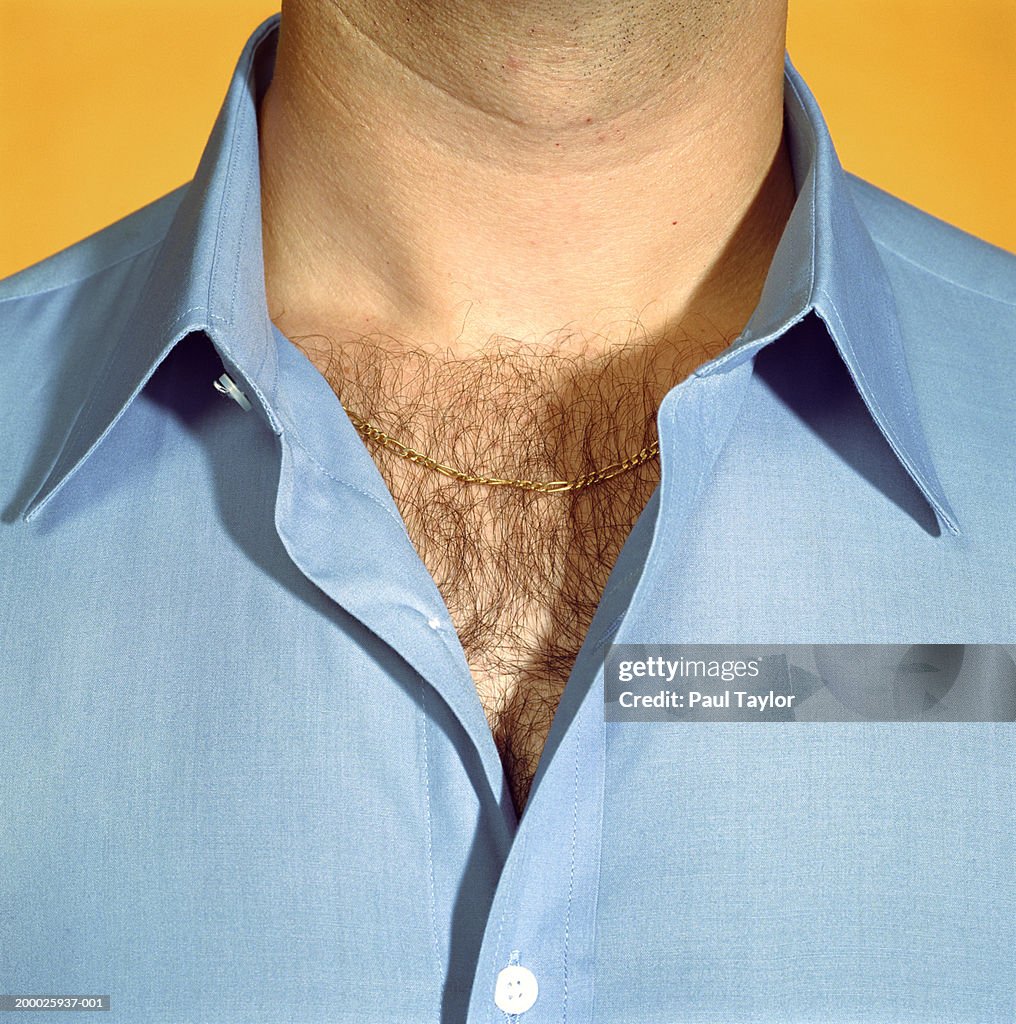 Man wearing blue shirt with chest hair visible, close-up