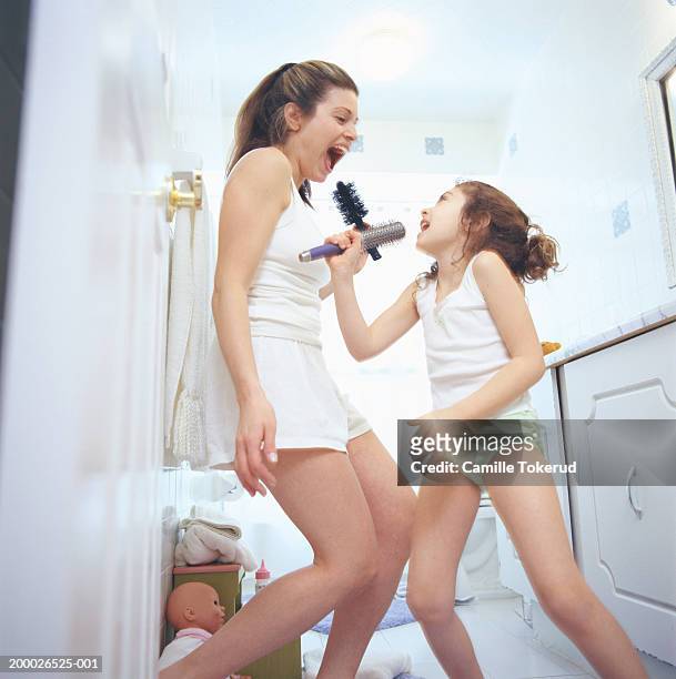 mother and daughter (4-6) dancing and singing in bathroom - kids in undies 個照片及圖片檔