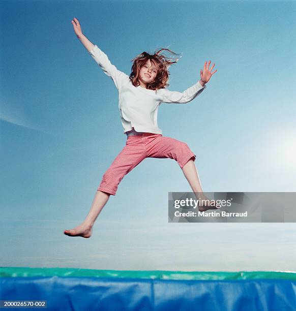 girl (8-10) bouncing on trampoline - trampoline photos et images de collection