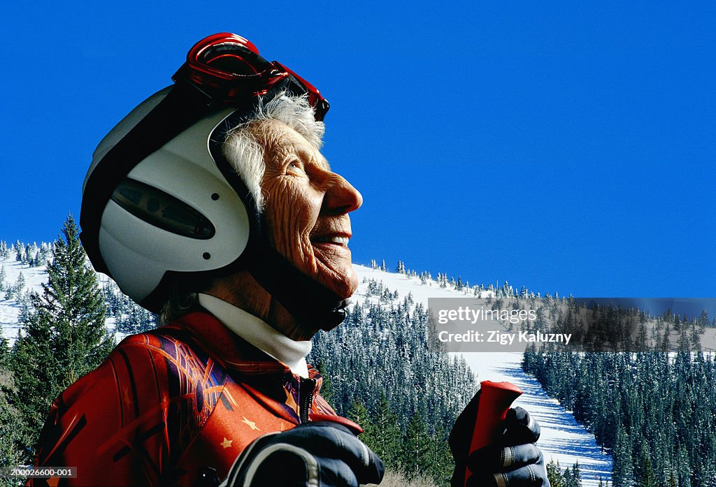 Mature woman wearing ski gear, looking upwards