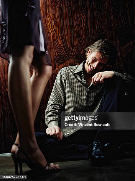 young couple (focus on man sitting at woman's feet) - awkward date stock-fotos und bilder