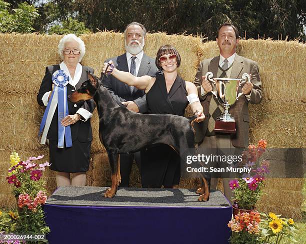 judges and owner with winning doberman pinscher at dog show - talentrichter stock-fotos und bilder