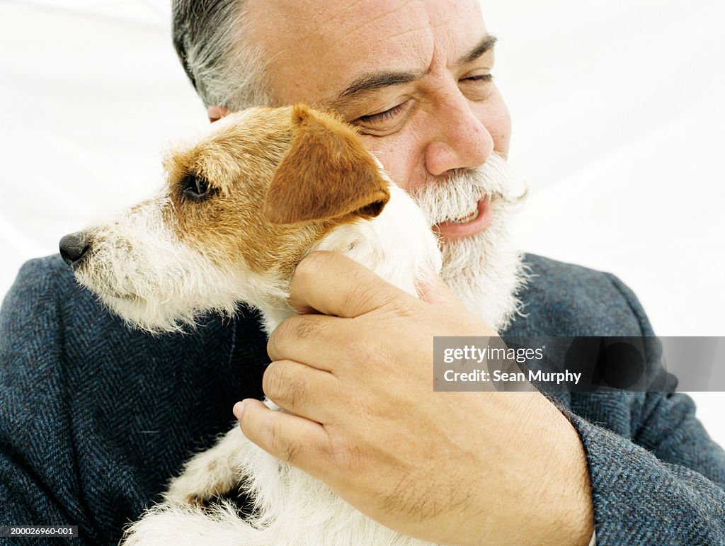Mature man hugging Jack Russell Terrier