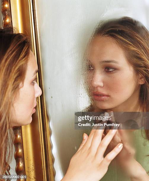 reflection of woman wiping condensation from mirror, close-up - steamy mirror stock pictures, royalty-free photos & images