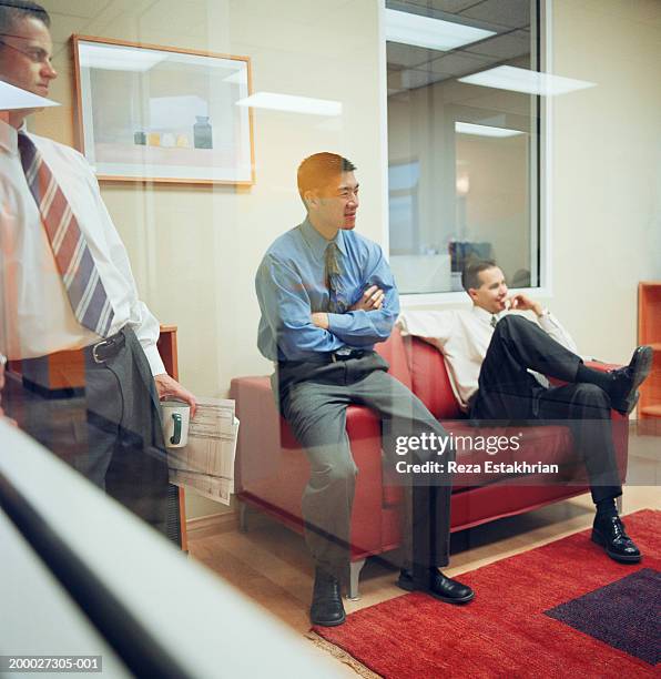 businessmen having casual meeting in office, view through window - stoneplus1 stock pictures, royalty-free photos & images