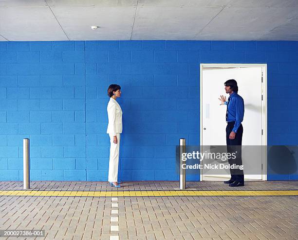 man and woman opposite each other in car park, man pushing door open - man opening door woman bildbanksfoton och bilder