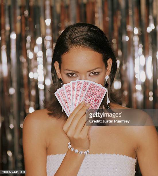 young woman looking over hand of cards, portrait - cartas na mão imagens e fotografias de stock