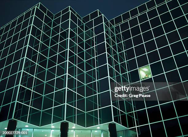 businessman in office at night, low angle view (digital composite) - working late foto e immagini stock