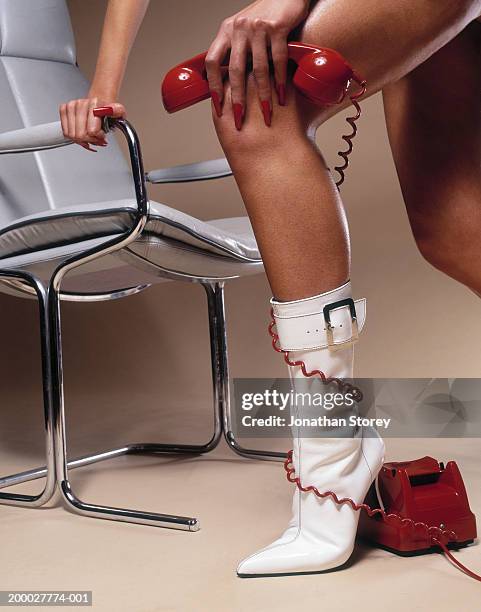 young woman with telephone cable wrapped around ankle, low section - bound in high heels stock-fotos und bilder