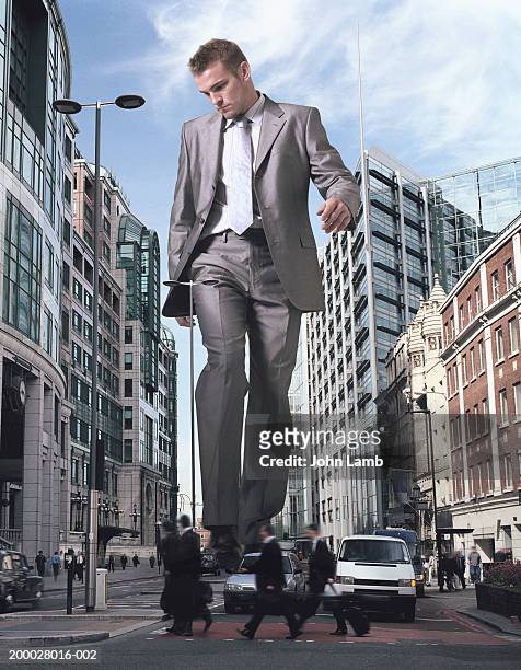 england, london, financial district, giant businessman walking street - bigger photos et images de collection