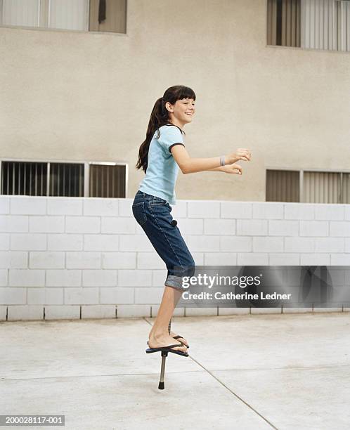 teenage girl (13-15) balancing on pogo stick - pogo stick stock pictures, royalty-free photos & images