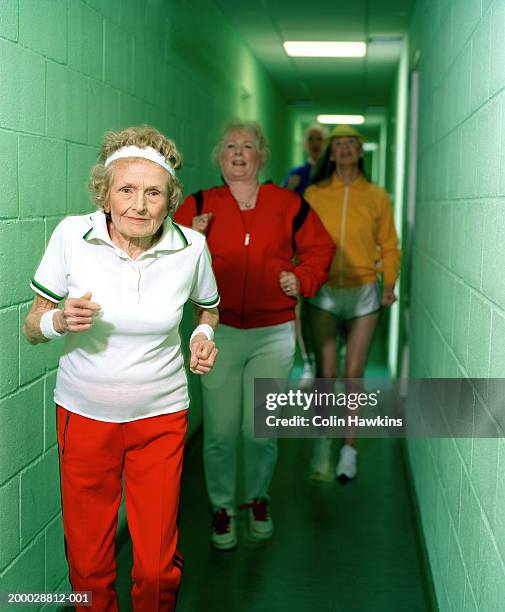 group of people running in corridor lead by senior woman, portrait - sweat band stock pictures, royalty-free photos & images