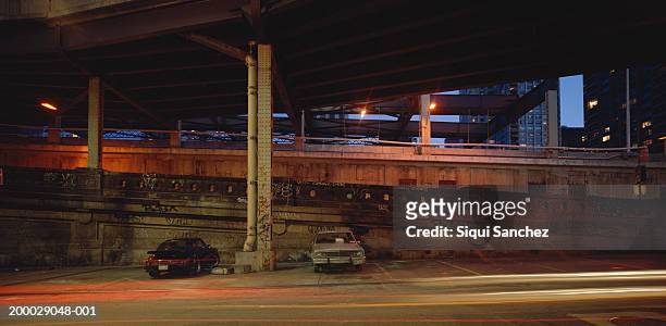 cars parked under bridge in city (long exposure) - クイーンズボロ橋 ストックフォトと画像