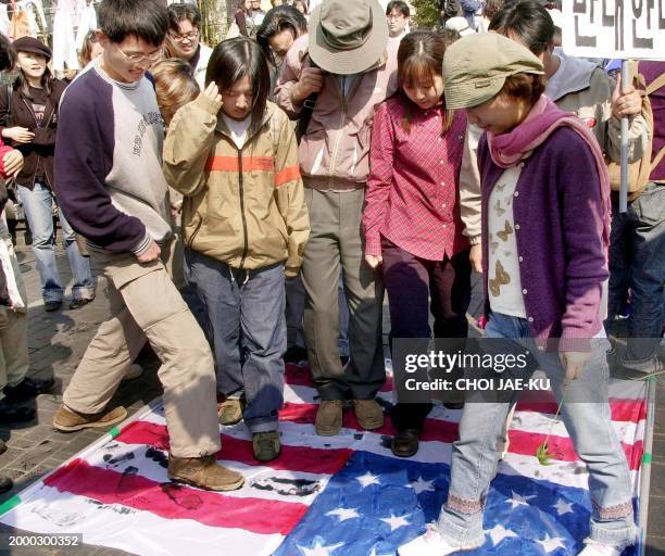 South Koreans stomp with black ink on a US flag during an anti-war demonstration in Seoul, 08 October 2002. The protesters shouted anti-US and...