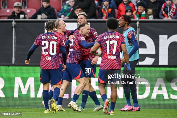 Benjamin Sesko of RB Leipzig celebrates after scoring his team's second goal with teammates during the Bundesliga match between FC Augsburg and RB...