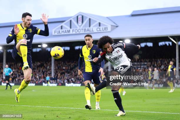 Willian of Fulham shoots under pressure from Adam Smith of AFC Bournemouth during the Premier League match between Fulham FC and AFC Bournemouth at...