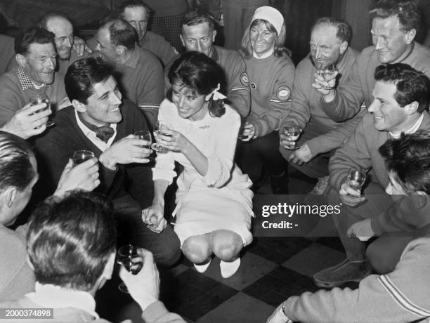 Le chanteur français Sacha Distel et sa jeune épouse Francine Bréaud, trinquent le 26 janvier 1963, entourés de moniteurs de ski, après leur mariage...