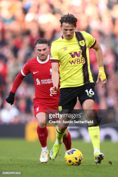Sander Berge of Burnley runs ahead of Alexis Mac Allister of Liverpool during the Premier League match between Liverpool FC and Burnley FC at Anfield...
