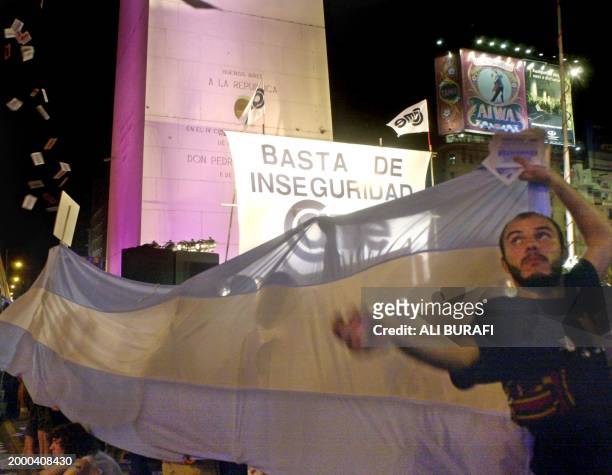 Businessmen and neighbors of Buenos Aires wave flags in front of the Obelisk during a demonstration protesting the insecurity, 10 October 2002. The...