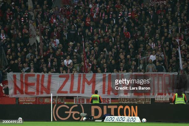 Fans hold up a banner in protest against DFL investors during the Bundesliga match between Bayer 04 Leverkusen and FC Bayern München at BayArena on...