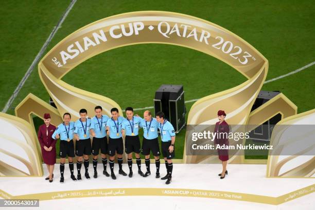 Match Referee Ma Ning and match officials pose for a photo with their medals following the AFC Asian Cup final match between Jordan and Qatar at...