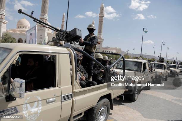 Security troops ride vehicles carrying coffins of Yemen's Houthi fighters, who were killed in US-UK air strikes, after a funeral ceremony at...