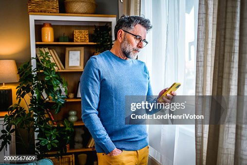 Mature man using phone at home Mature man using phone at home