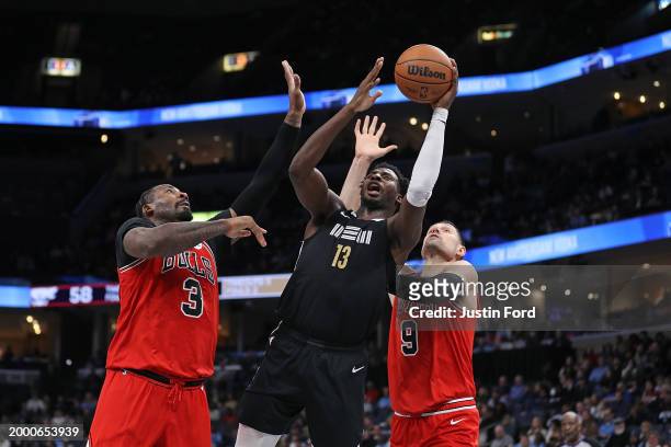 Jaren Jackson Jr. #13 of the Memphis Grizzlies goes to the basket against Andre Drummond of the Chicago Bulls and Nikola Vucevic of the Chicago Bulls...
