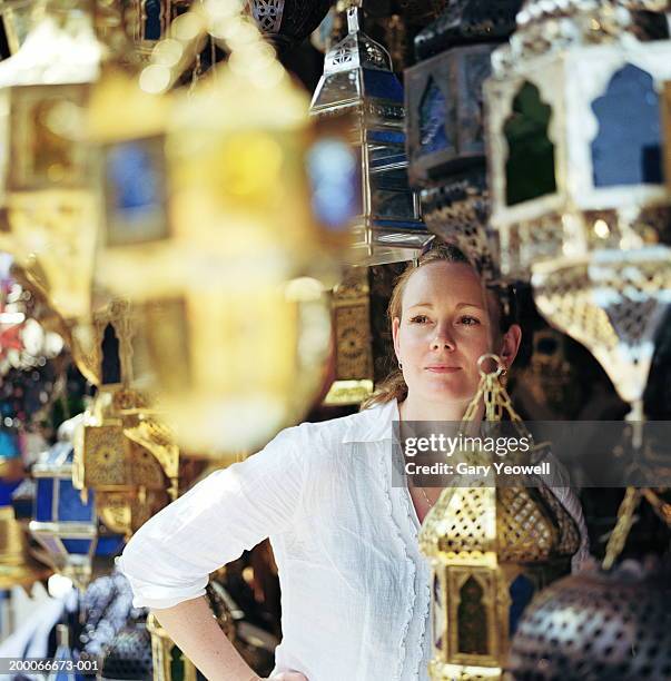 morocco, marrakesh, woman looking at silverware (focus on woman) - morocco tourist stock pictures, royalty-free photos & images