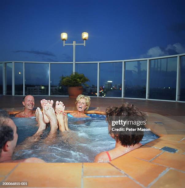 two mature couples playing footsie in hot tub - playing footsie stock-fotos und bilder