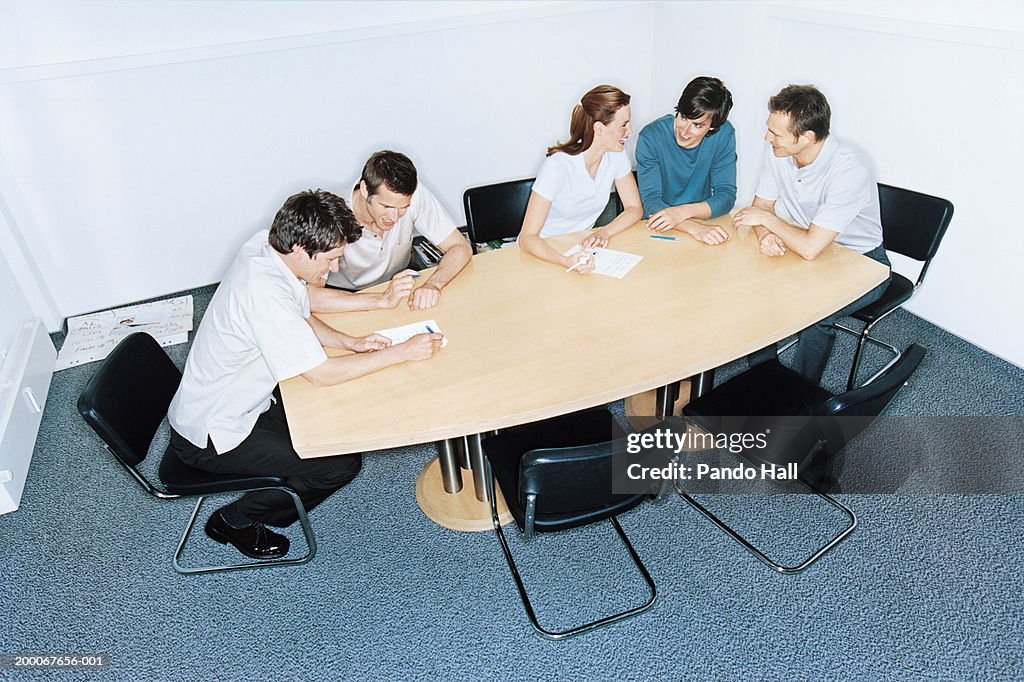 Group of businessmen and woman working at table in conference room