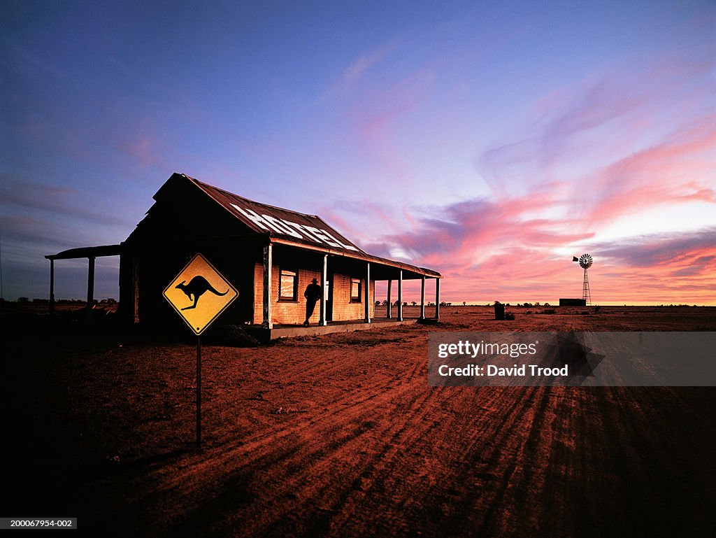 Australia, New South Wales, man standing on hotel porch, silhouette