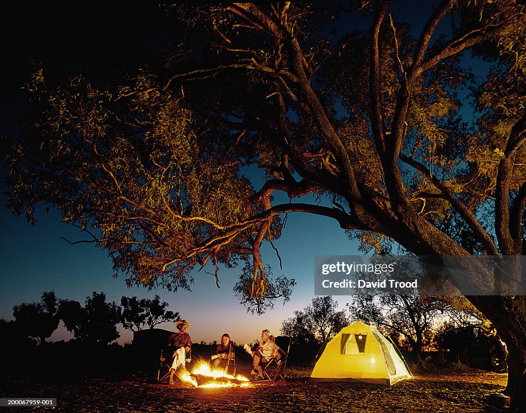 Family around camp fire, night (Digital Composite)
