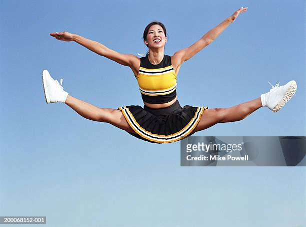 cheerleader doing splits in mid air - asian cheerleaders stock-fotos und bilder