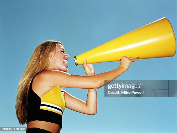 cheerleader yelling through megaphone, low angle, side view - cheerleaders dance team stock pictures, royalty-free photos & images