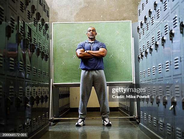 coach in locker room, standing in front of chalkboard - sport trainerin stock-fotos und bilder