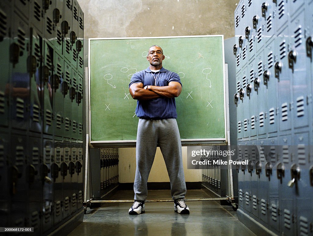 Coach in locker room, standing in front of chalkboard