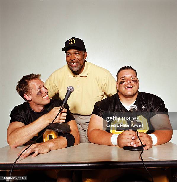 football players with coach in press conference - sporting press conference stock pictures, royalty-free photos & images