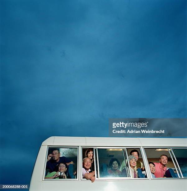 group of mature passengers looking out of coach windows - coach bus stock-fotos und bilder
