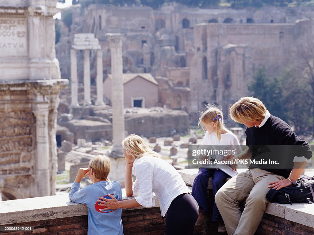 Italy, Rome, family reading guide book, looking out over Forum Romanum