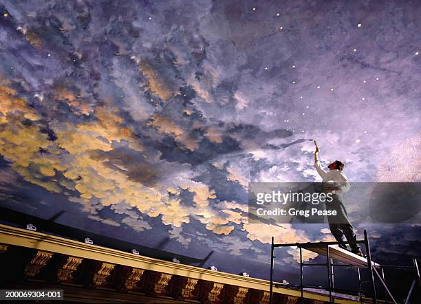 man painting mural on ceiling, low angle view (digital composite) - schilder kunstenaar stockfoto's en -beelden