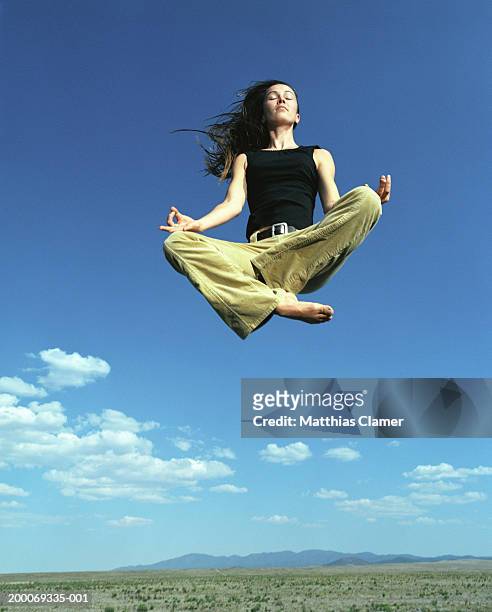 woman in yoga position in mid air - floating foto e immagini stock