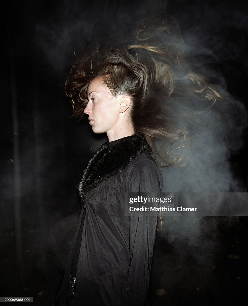 Woman's hair blowing in smoke, side view