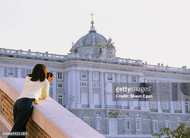 spain, madrid, woman taking photograph of royal palace, rear view - koninklijk paleis van madrid stockfoto's en -beelden