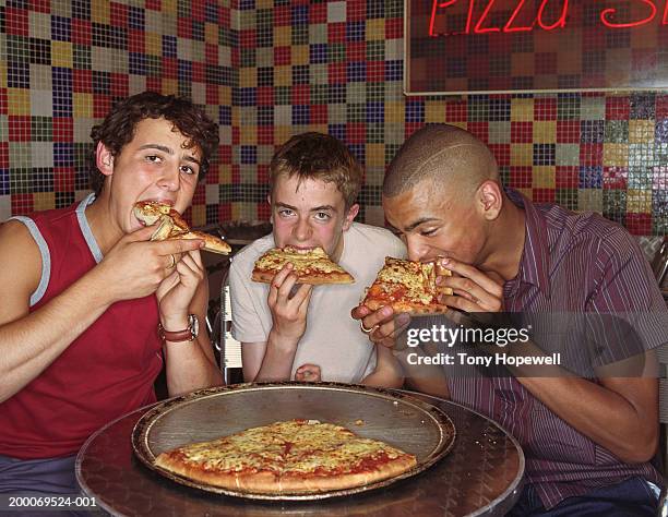 three teenage boys (15-18) eating pizza - pizza stand stock pictures, royalty-free photos & images