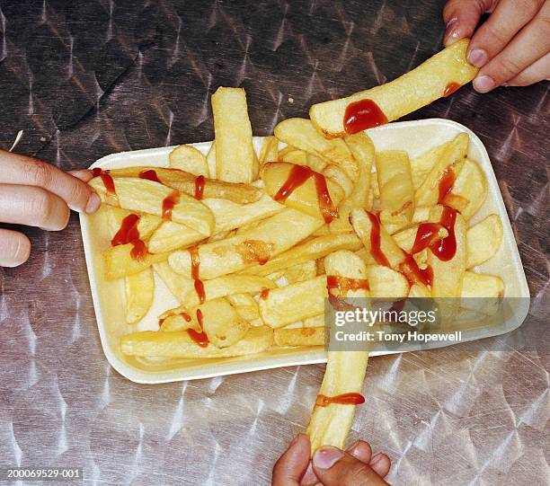 three teenage boys (15-18) sharing portion of chips, close-up - 3 fingers stock-fotos und bilder