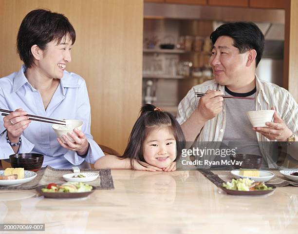mother, father and daughter (2-4) eating meal at home - meal ストックフォトと画像