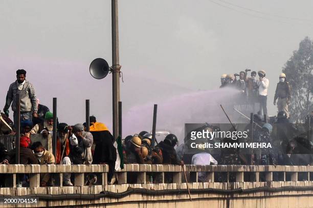Police use a water canon to disperse and and prevent farmers from march towards India's capital during a protest demanding minimum crop prices, at...